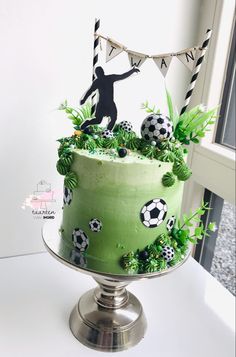 a green cake with soccer decorations on it