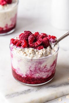 raspberry cheesecake trifle in a glass bowl with a spoon on the side