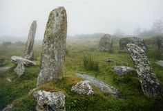 several large rocks in the middle of a grassy field