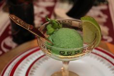 a small glass filled with green stuff on top of a table