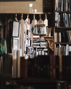 a bookshelf filled with lots of books next to a wall full of books