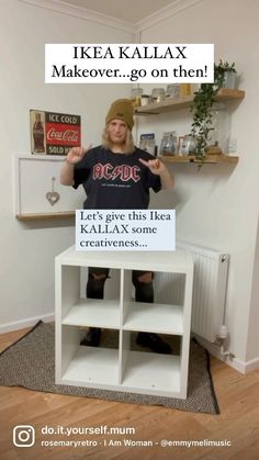 a man standing in front of a white shelf holding a sign