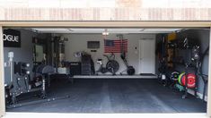 a garage with an american flag hanging on the wall and various gym equipment in it