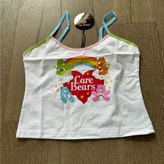 This Cute Tank Top From Dolls Kill X Care Bears Features Contrast Rainbow Trim And Graphic Print On The Front. New With Tags Size Xl Playful White Tank Top For Summer, White Y2k Cotton Tank Top, White Cotton Y2k Tank Top, White Cotton Y2k Style Tank Top, White Fun Tank Top For Spring, Fun White Tank Top For Spring, Fun White Spring Tank Top, White Printed Y2k Tops, Trendy Printed White Tank Top