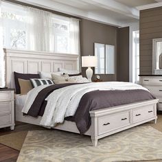 a white bed sitting in a bedroom next to a dresser and mirror on top of a wooden floor