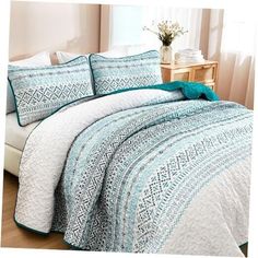 a bed covered in a blue and white quilt