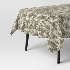 an image of a table cloth with green leaves on the top and black wooden legs