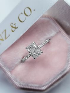 an engagement ring in a pink velvet box with the name n & co on it