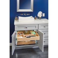 an open drawer in front of a sink with drawers underneath it and a mirror above the sink