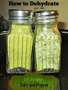 two jars filled with green food sitting on top of a counter next to a red and white checkered table cloth