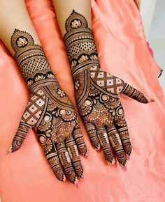 two hands with henna designs on them