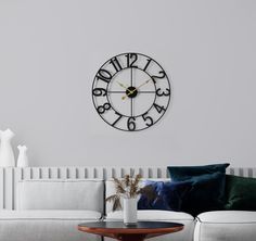 a living room with a couch, coffee table and large clock on the wall