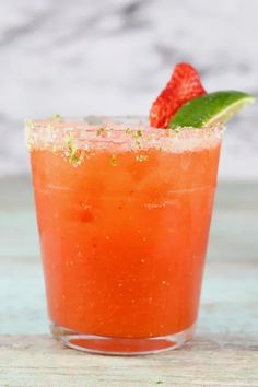 a close up of a drink with strawberries on the rim and garnish