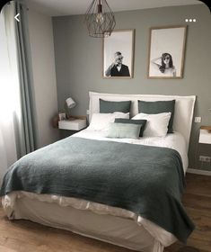 a bed with two pictures on the wall above it