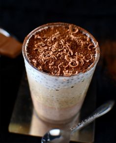 there is a chocolate drink in the glass with whipped cream and chocolate shavings on top