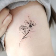 a woman's stomach with a flower tattoo on it