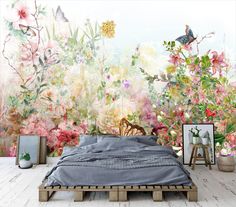 a bedroom with flowers on the wall and a large bed in front of it,