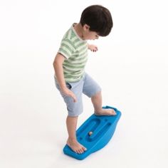 a young boy standing on a blue plastic toy