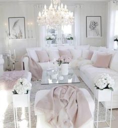 a living room filled with white furniture and lots of pink pillows on top of it