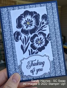 a hand holding up a card with flowers on it and the words thinking of you