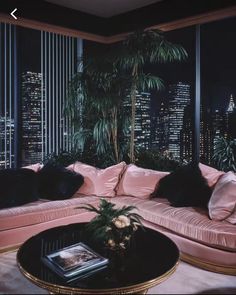 a living room filled with pink couches next to a window covered in black pillows