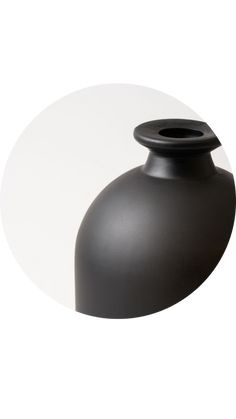 a black vase sitting on top of a white table