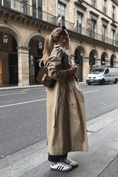 Linked to a similar trench coat with a timeless and feminine silhouette 🤎 #adlink | Minimal and classic look in a trench coat and dark jeans | Full lenght trench coat, beige trench coat, spring outfit, Outfit ideas, spring outfit, outfit inspiration, spring outfit 2024, spring fashion, minimal style, minimal outfit, capsule wardrobe, adidas samba, adidas samba outfit, demellier bag, demellier london bag, beige outfit, 👈everyday outfit, outfit ideas for spring, fashion ideas, cred: mildagud Rainy Trench Coat Outfit, Trench Outfit Women, Zara Trench Coat Outfit, Trench Coat Outfit Inspiration, Green Jacket Winter Outfit, Trench Coat Autumn Outfit, Beige Oversized Coat Outfit, Trench Spring Outfit, Boots And Trench Coat Outfit