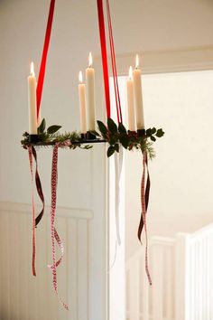 a candle chandelier with candles and ribbons hanging from it