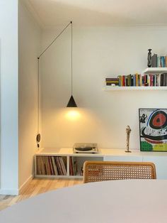 a room with a table, bookshelf and shelves