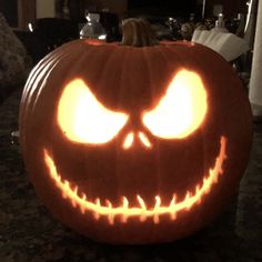 a carved pumpkin with glowing eyes on it's face, sitting on a table