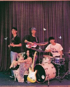 the band is posing for a photo in front of a curtain with butterflies on it