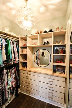 the closet is full of clothes and shoes, including one large round mirror that hangs on the wall