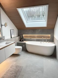 a bathroom with a skylight above the sink and bathtub in front of it