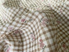 the fabric has flowers on it and is brown with white checkerboard pattern,