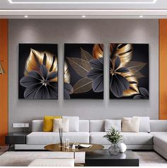 three paintings are hanging on the wall above a couch and coffee table in a modern living room