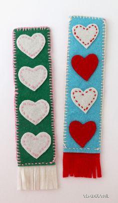 two handmade valentine's day bookmarks made from felt and yarn with hearts on them