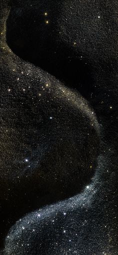 an image of stars in the night sky with black sand and water flowing down it