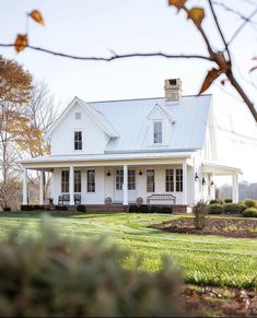 a white house sitting on top of a lush green field