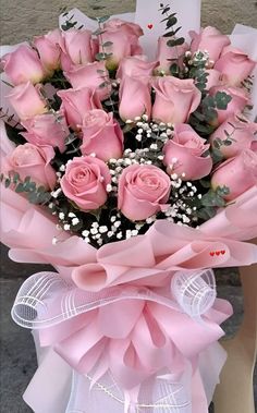 a bunch of pink roses in a bouquet