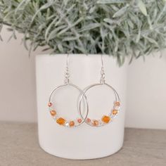 Show your team spirit with these handmade wire wrapped Tennessee Vols hoop earrings. Featuring vibrant orange & iridescent beads and silver plated, they're the perfect accessory for cheering on the Tennessee Volunteers. Whether you're tailgating or watching the game, these earrings are a stylish way to support your favorite football team. Get ready to score some style points with these Vols-inspired earrings! To keep your silver-plated jewelry looking its best, we recommend avoiding contact with harsh chemicals, perfumes, and excessive moisture. Gently wipe it clean with a soft cloth after wearing to preserve its shine and quality. **I use a combination of high quality glass beads, acrylic beads and natural stones for all of my items. My main goal is to create beautiful peices that are als Tennessee Vols, Handmade Wire Wrapped, Tennessee Volunteers, Silver Plated Jewelry, Handmade Wire, Vibrant Orange, Jewelry Earrings Hoops, Acrylic Beads, Team Spirit