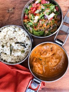 three pans filled with food on top of a wooden table