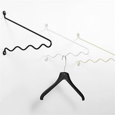 three black and white clothes hangers on a wall