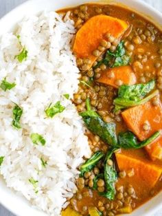 a white bowl filled with rice, lentils and sweet potato curry next to a spoon