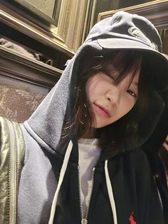 a young woman wearing a hoodie and looking at the camera