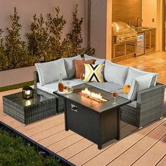 a fire pit sitting on top of a wooden deck next to a patio with furniture