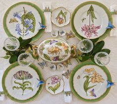 a table topped with lots of plates covered in flowers