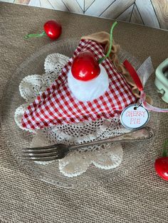 a piece of cake on a plate with cherries and a fork next to it