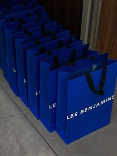 blue shopping bags are lined up on the floor