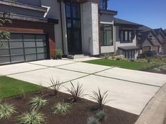 a house that has grass in the front yard and landscaping on the side of it