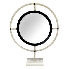 a white and black circular mirror on a stand